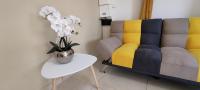 - un salon avec un canapé et une table fleurie dans l&#39;établissement T2 Morpho - moderne et chaleureux, à Rémire-Camp