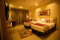 una habitación de hotel con dos camas y un sofá en Royal Orchid Central, Shimoga, en Shimoga