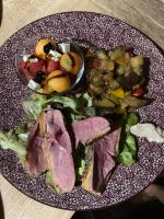 Un plato de comida con carne y verduras en una mesa. en Le Clos Bô-m, en Marignieu