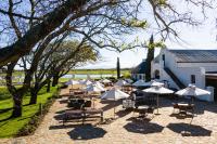 a group of tables and chairs with umbrellas at Vergenoegd Löw Boutique Hotel & Spa in Cape Town