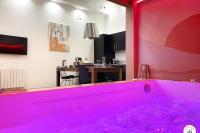 a hot pink bath tub in a room with a kitchen at l&#39;Orient-Express - Jacuzzi SPA - Parking - Loft in Le Havre