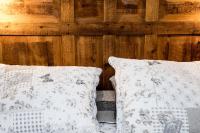 2 almohadas sentadas en una cama junto a una pared de madera en KB68, en Kaysersberg