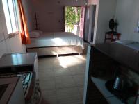 Un dormitorio pequeño con una cama y una ventana. en Paracuru HolaOnda WaveHostel, en Paracuru