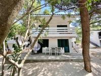 una casa blanca con una mesa y sillas frente a ella en Family Resort Urania, en Baška Voda
