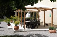 a patio with a table and chairs under a pavilion at Glamping at Camping La Source in Saint-Pierre-dʼArgençon
