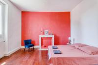 a red bedroom with a bed and a blue chair at L&#39;Ardeche en Provence avec jardin ombragé in Pont-Saint-Esprit