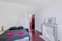 a bedroom with a bed with pink pillows and a fireplace at L&#39;Ardeche en Provence avec jardin ombragé in Pont-Saint-Esprit