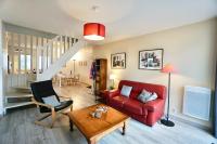 a living room with a red couch and a table at Le duplex du quai mer in Concarneau