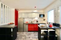 a kitchen with red cabinets and a stainless steel refrigerator at Le duplex du quai mer in Concarneau