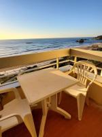 a table and chairs on a balcony with the ocean at Biarritz centre balcon vue mer, piscine, plage in Biarritz