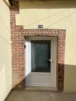 a brick building with a door with a sign on it at Studio centre village Soligny la Trappe proche Mortagne au perche in Soligny-la-Trappe