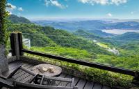 a balcony with two chairs and a table and a view at Sunny Room in Jiufen