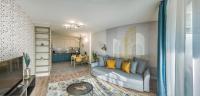 a living room with a couch and a kitchen at Vagabond SOHO in Budapest