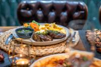 um prato de alimentos com carne e batatas fritas numa mesa em Sky Roof Hotel em Lefkosa Turk