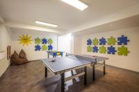 a ping pong table in a room with puzzles on the wall at Appartements Schedererhaus in Going am Wilden Kaiser