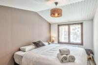 - une chambre avec un grand lit blanc et une fenêtre dans l&#39;établissement Appartement Feige - Welkeys, à Megève
