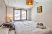 - une chambre avec un grand lit blanc et 2 serviettes dans l&#39;établissement Appartement Feige - Welkeys, à Megève