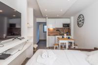 Cet appartement comprend une chambre avec un lit blanc et une cuisine. dans l&#39;établissement Appartement Feige - Welkeys, à Megève