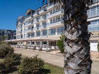 a building with tables and chairs in front of it at Westotel Le Pouliguen in Le Pouliguen