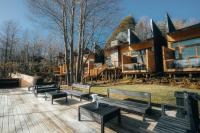 a group of benches sitting on a deck in front of a log cabin at NI-NEWEN Hotel &amp; Lodge in Pucón