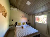 a bed in a room with a wooden ceiling at Chico de Sá Pousada in Pirenópolis