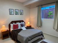 a bedroom with a bed with two lamps and a window at Chico de Sá Pousada in Pirenópolis