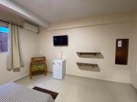 a room with a tv and a bed and a chair at Chico de Sá Pousada in Pirenópolis
