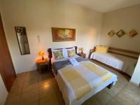 a bedroom with two beds and a mirror at Chico de Sá Pousada in Pirenópolis