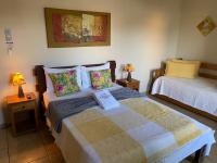 a bedroom with two beds and two lamps on tables at Chico de Sá Pousada in Pirenópolis