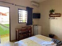 a bedroom with a bed and a table and a window at Chico de Sá Pousada in Pirenópolis