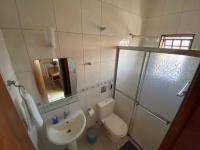 a bathroom with a sink and a toilet and a shower at Chico de Sá Pousada in Pirenópolis