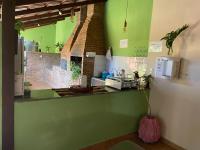 a kitchen with green walls and a counter with a sink at Chico de Sá Pousada in Pirenópolis