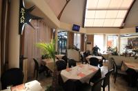 Un restaurante con mesas y sillas y un hombre al fondo. en Hotel Star, en Monterotondo