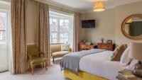 Un dormitorio con una cama y un escritorio y una ventana. en The Bear Hotel, en Wareham