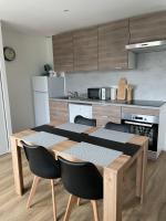 a kitchen with a wooden table and chairs in a kitchen at Résidence Pelloutier Appartement F in Vénissieux