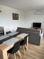 a living room with two tables and a couch at Résidence Pelloutier Appartement F in Vénissieux