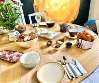 a wooden table topped with plates and bowls of food at Maison Alfred et Agatha in Pleudihen-sur-Rance