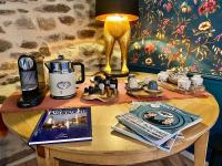 a table with a coffee maker and a magazine on it at Maison Alfred et Agatha in Pleudihen-sur-Rance
