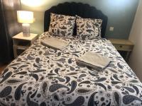 a bed with a black and white comforter and pillows at Maison de Charme Rénovée in Cucuron