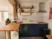 a kitchen with blue cabinets and a wooden counter top at Pavillon d&#39;Aÿ cottage Champagne - Label Green Key in Ay