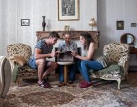 3 Personen sitzen um einen Tisch im Wohnzimmer in der Unterkunft Gamotel in Vitteaux