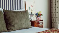 a bed with a pillow and a vase of flowers on a table at Maison Saintonge in Paris