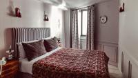 a bedroom with a bed with a red blanket and a window at Maison Saintonge in Paris