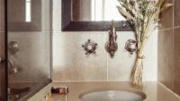 a bathroom sink with a mirror and a vase of flowers at Maison Saintonge in Paris