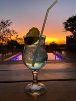 a glass of water with a lime and a straw at Roaring Sky Base Camp in Baviaanspoort