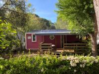 a red cabin with a porch in a garden at Mobile home 5-pers Camping Leï Suves-Côtes d&#39;Azur-including airco in Roquebrune-sur-Argens