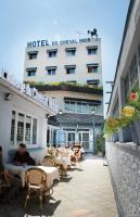 a hotel with tables and chairs in front of a building at Le Cheval Noir Hôtel Paris Pantin in Pantin