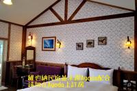 a bedroom with a bed and a wall with pictures on it at Cingjing Vienna Pleasance Cottage in Ren&#39;ai