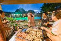 een groep mensen die rond een grill staan met eten bij Star Hill Village Resort Phu Quoc in Phu Quoc