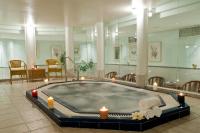 ein Whirlpool in einem Raum mit Kerzen und Stühlen in der Unterkunft U Magic Palace in Eilat